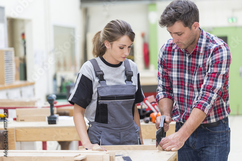 young apprentice with professional carpenter photo