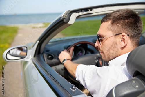 happy man driving cabriolet car outdoors