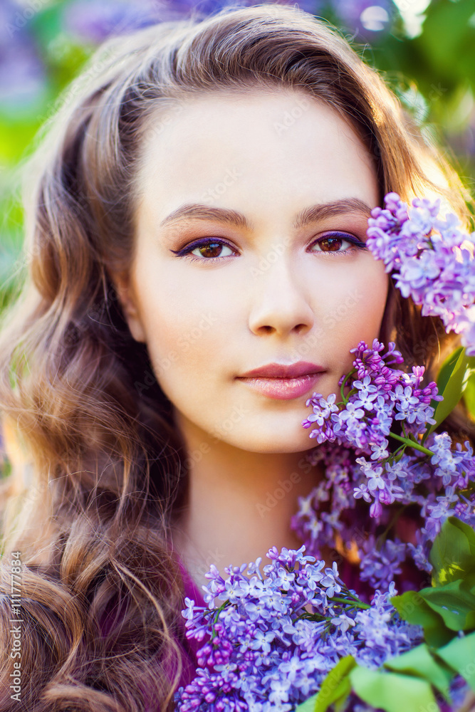 Young beautiful girl near lilac bushes in blossom Young beautiful girl near lilac bushes in blossom
