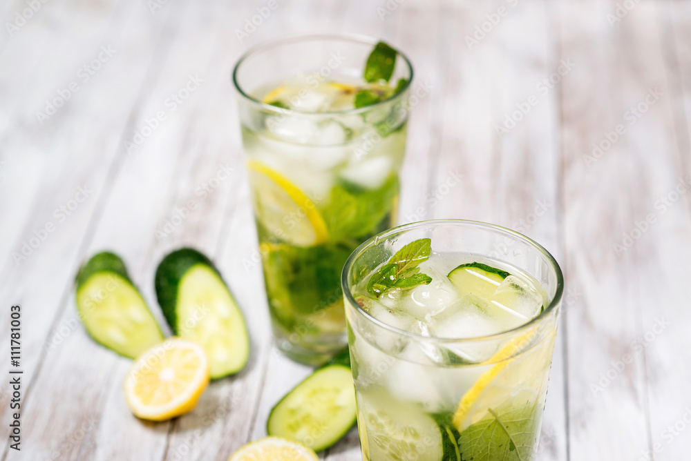Water with lemon, mint and cucumber on wooden light background. Water Detox. Water with lemon, mint and cucumber on wooden light background. Water Detox.