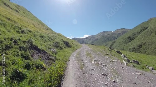 Motorcycle riding on Zagar Pass dirt road high up in the Caucasus Mountains in Georgia photo
