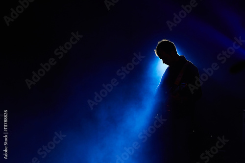 Chitarrista con faro blu su fondo nero