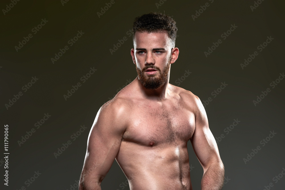 Handsome young body builder, on grey background