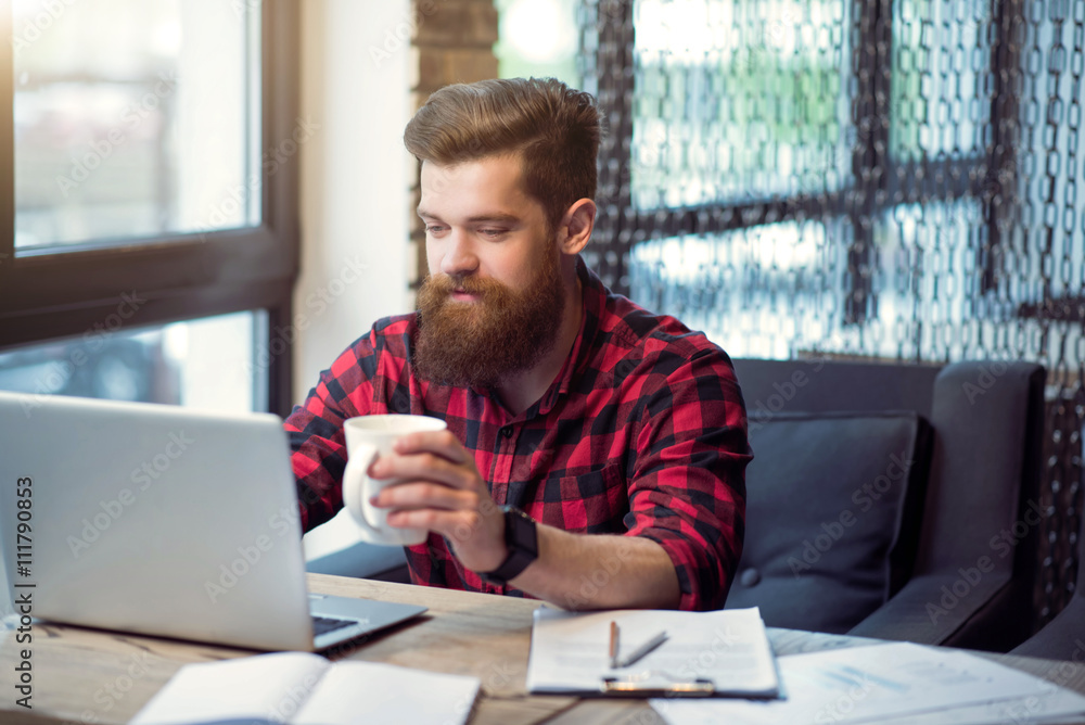 Cheerful bearded man sitting at the table Cheerful bearded man sitting at the table