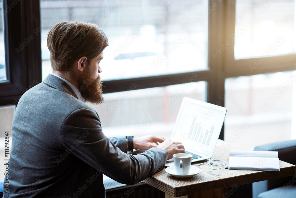 Pleasant bearded man sitting at the table Pleasant bearded man sitting at the table