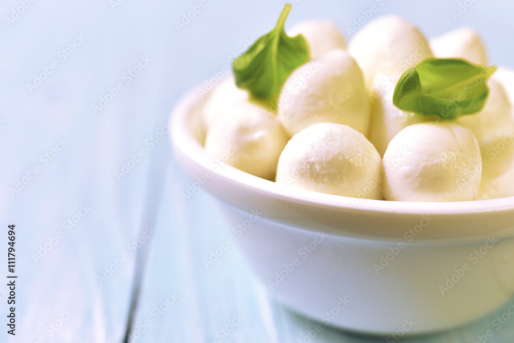 Small white mozzarella balls in a white bowl. Small white mozzarella balls in a white bowl.