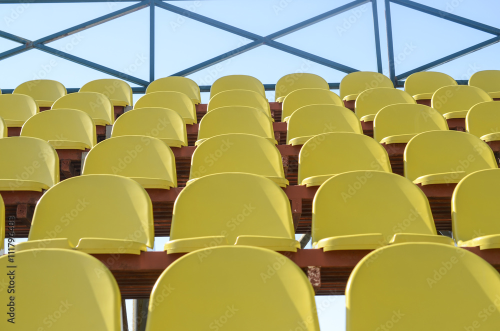 Fototapeta premium Rows of yellow plastic seats in the stadium