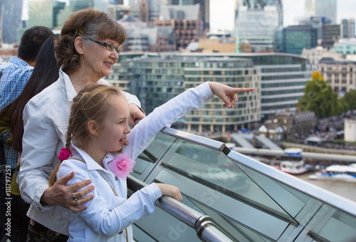 Elderly woman and granddaughter enjoying the London view. Background includes modern building City of London, business and banking aria photo