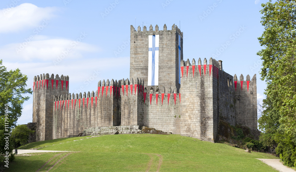 Guimaraes castle with the flag of the city, north of Portugal Guimaraes castle with the flag of the city, north of Portugal