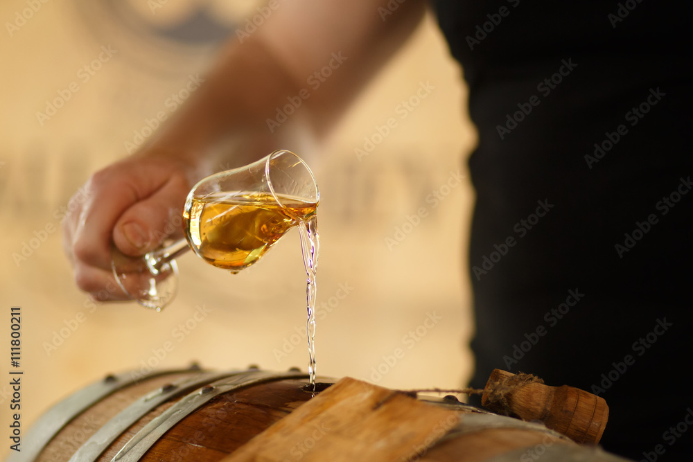 pour whiskey in barrels