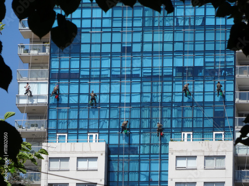 Gefährliche Arbeit am Seil in der Vertikalen, Glasreinigung an Hochhaus in Buenos Aires, Argentinien photo