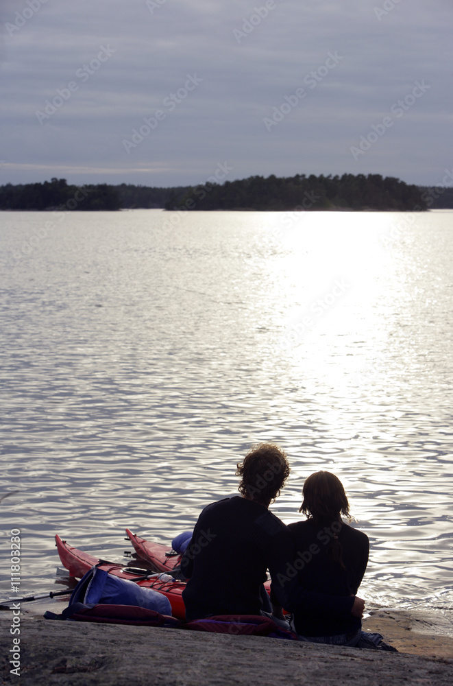 Silhouette of a couple sitting by the sea in the sunset. Silhouette of a couple sitting by the sea in the sunset.