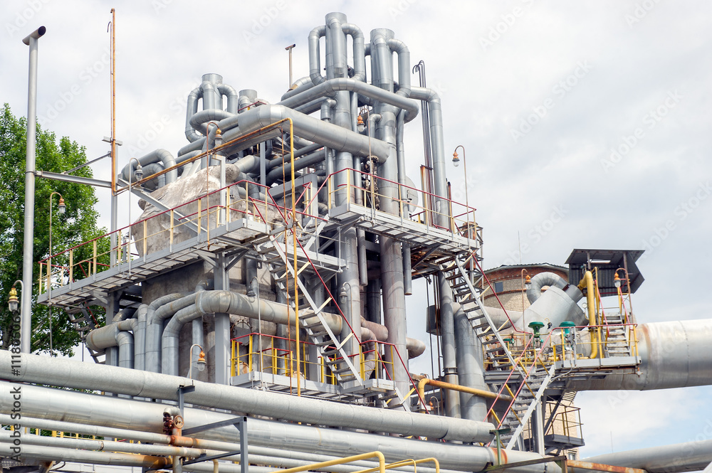 Industrial equipment and pipelines at the gas processing plant on a summer day Industrial equipment and pipelines at the gas processing plant on a summer day