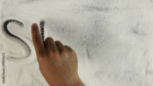 Men hand draws word stevia on the surface of sugar