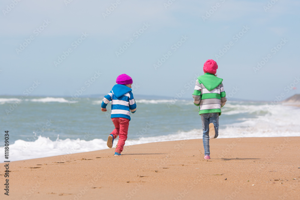 Two girls run a race on the beach seaside Two girls run a race on the beach seaside