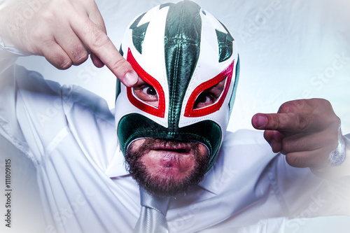 Shocked, angry businessman with Mexican wrestler mask, expressio photo