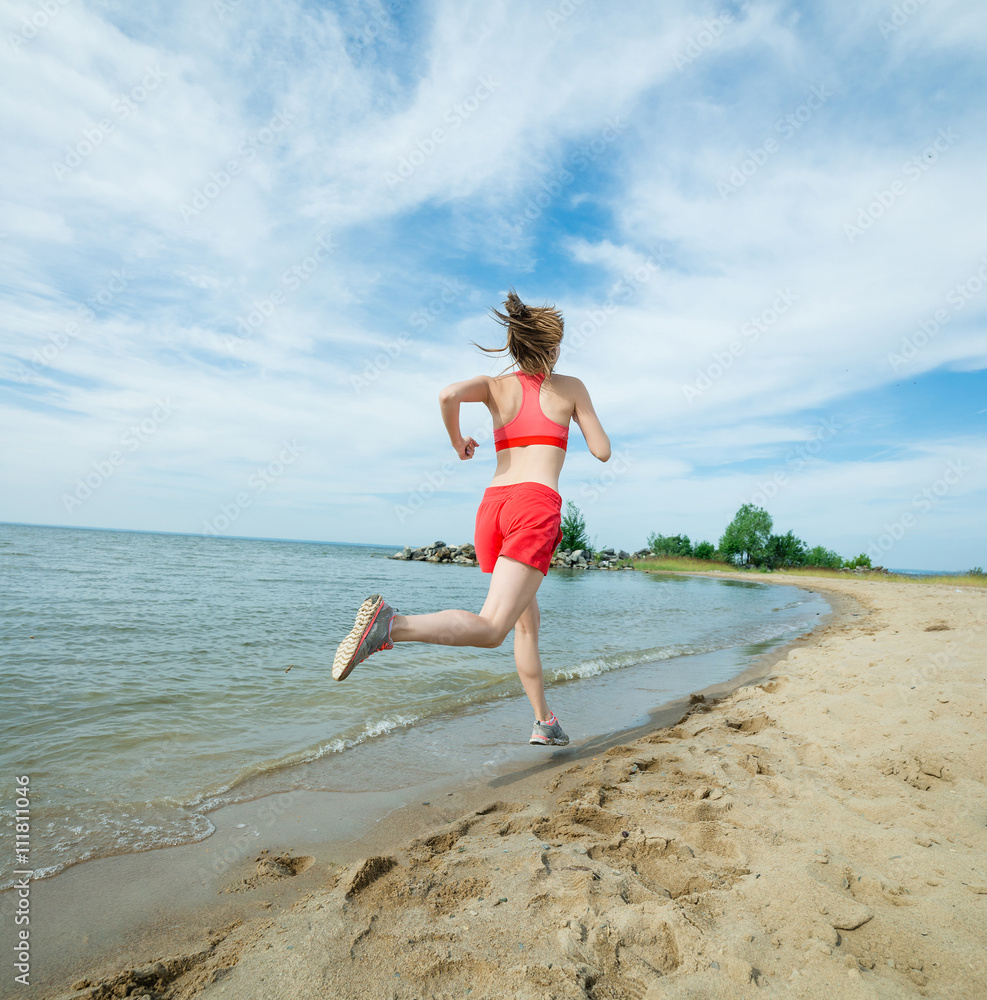 Young lady running. Woman runner running at the sunny summer sand beach. Workout near ocean sea coast. Beautiful fit girl. Fitness model caucasian ethnicity outdoors. Weight loss exercise. Jogging. Young lady running. Woman runner running at the sunny summer sand beach. Workout near ocean sea coast. Beautiful fit girl. Fitness model caucasian ethnicity outdoors. Weight loss exercise. Jogging.