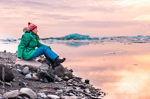 woman sitting on the beach of glacial lagoon, Iceland. Jokulsarlon Glacier Lagoon