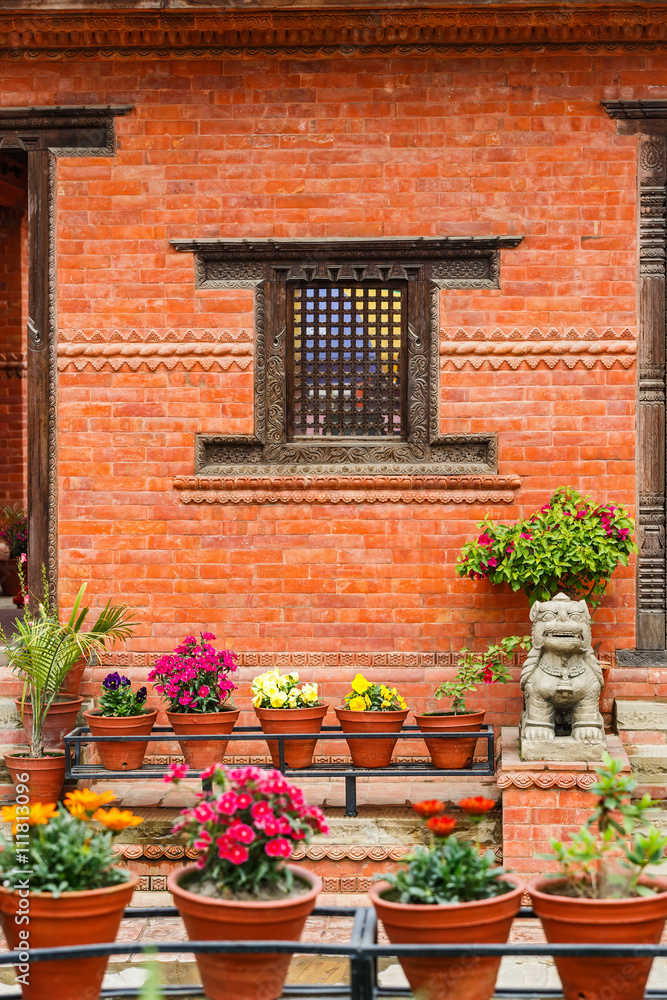 Carved wooden window on a brick wall