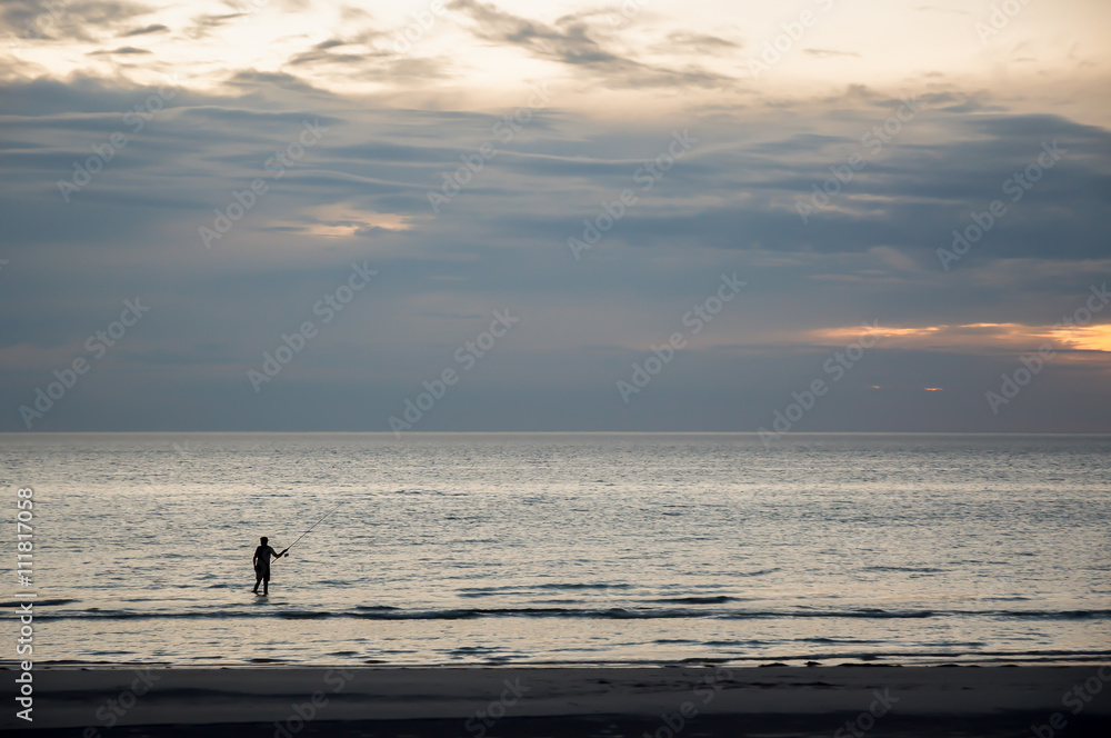 Fishing.
Evening shoot of solitary fisherman on an Australian beach.