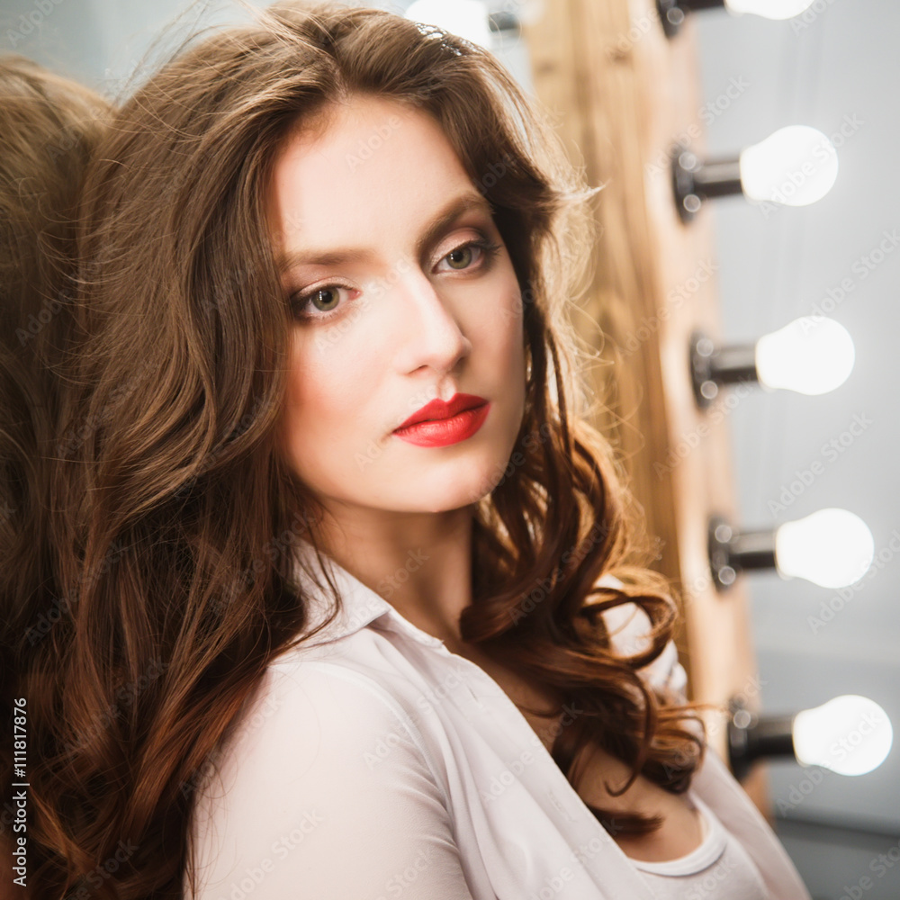 Naklejka premium Close-up portrait of beautiful sexy young woman with long brown hair in photostudio