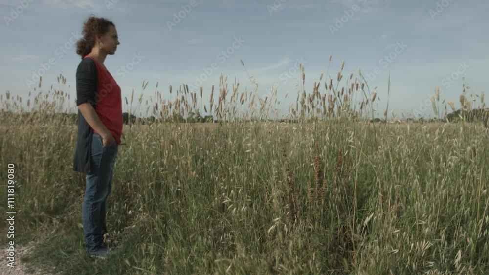 Donna con capelli ricci in un campo pensa e ricorda Donna con capelli ricci in un campo pensa e ricorda