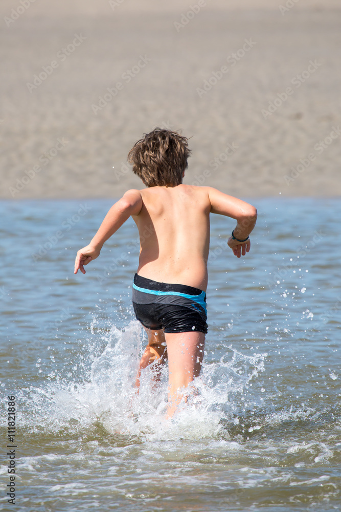 Junge sprintet durchs Meer