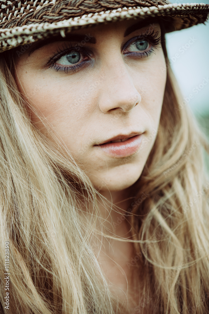 Portrait of pretty woman wearing white dress and straw hat in sunny warm weather day. Close up portrait.