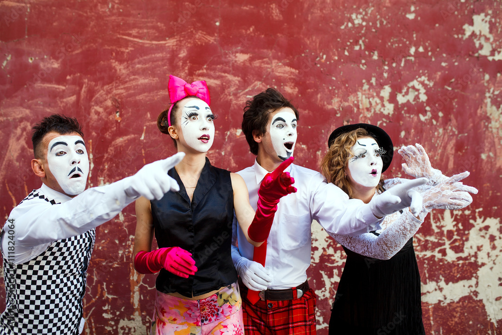 Four mimes looking aside on the background of a red wall. Four mimes looking aside on the background of a red wall.