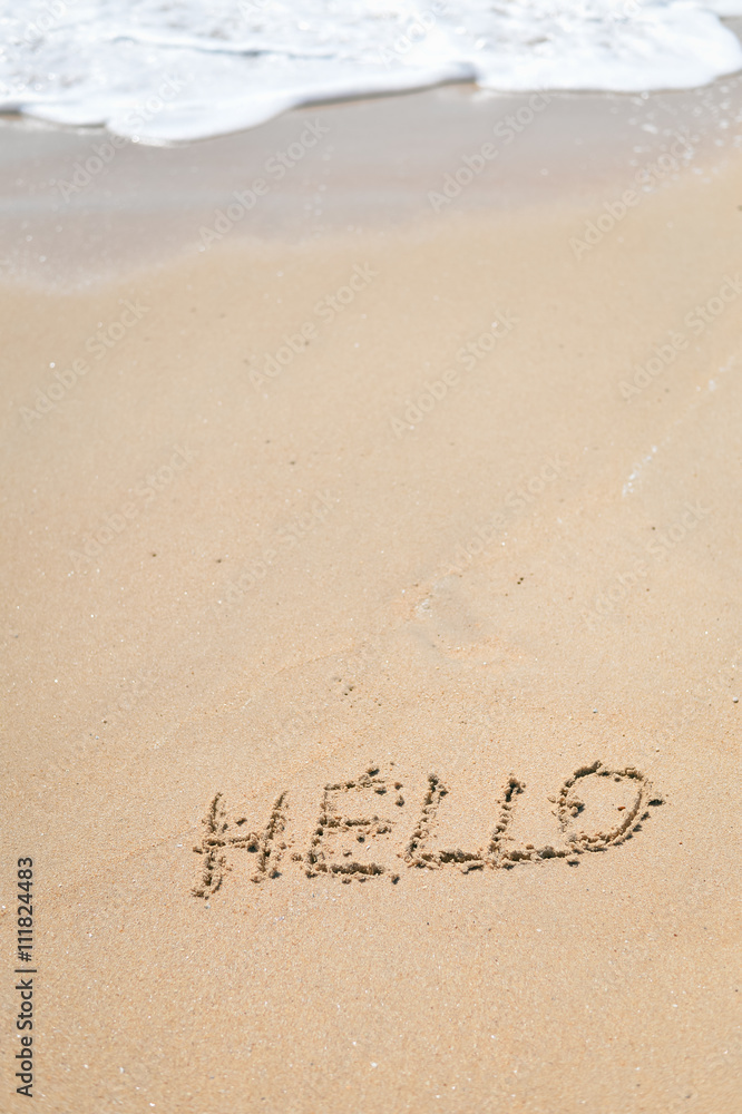 Fototapeta premium Top view of greeting sign drawing on the outside sand beach background
