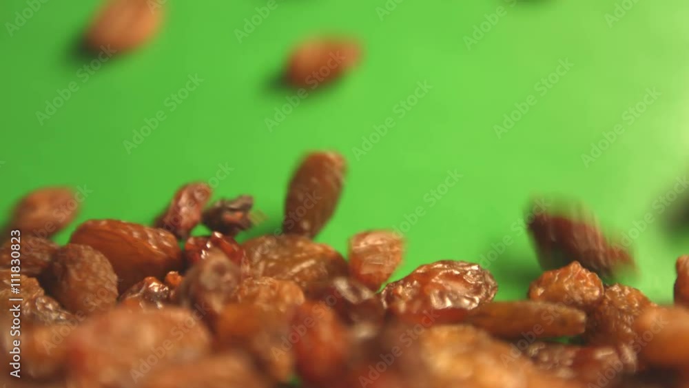 Raisins on a green background. 2 Shots. Horizontal pan. Close-up. Raisins on a green background. 2 Shots. Horizontal pan. Close-up.