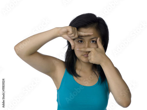 asian female making a picture frame with her fingers.