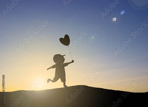 silhouette Kids play heart shaped balloons with sunset
