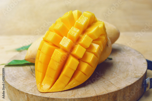 Obraz na płótnie ripe mango with mango leaf in wooden background.