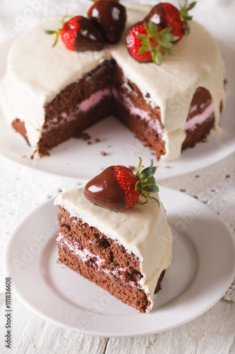 Cut a piece of cake with dark and white chocolate and strawberry. vertical 