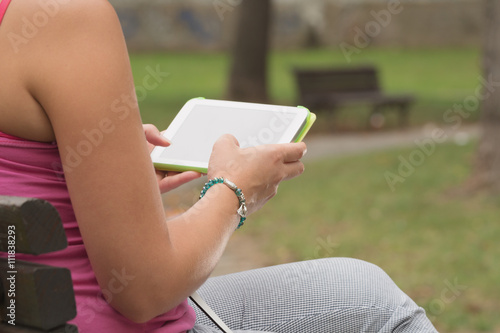 Girl using tablet in a park.