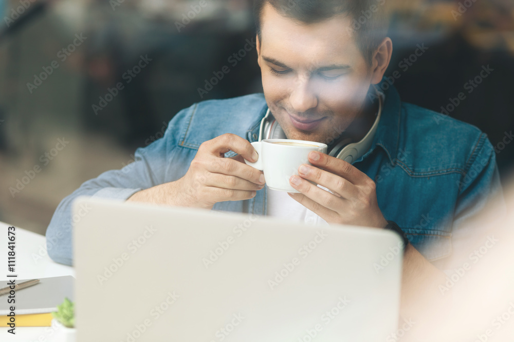 Attractive young guy is enjoying hot beverage Attractive young guy is enjoying hot beverage