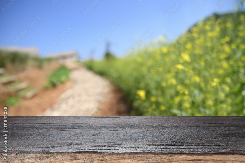 Fototapeta premium Wooden desk space platform on farm of field background