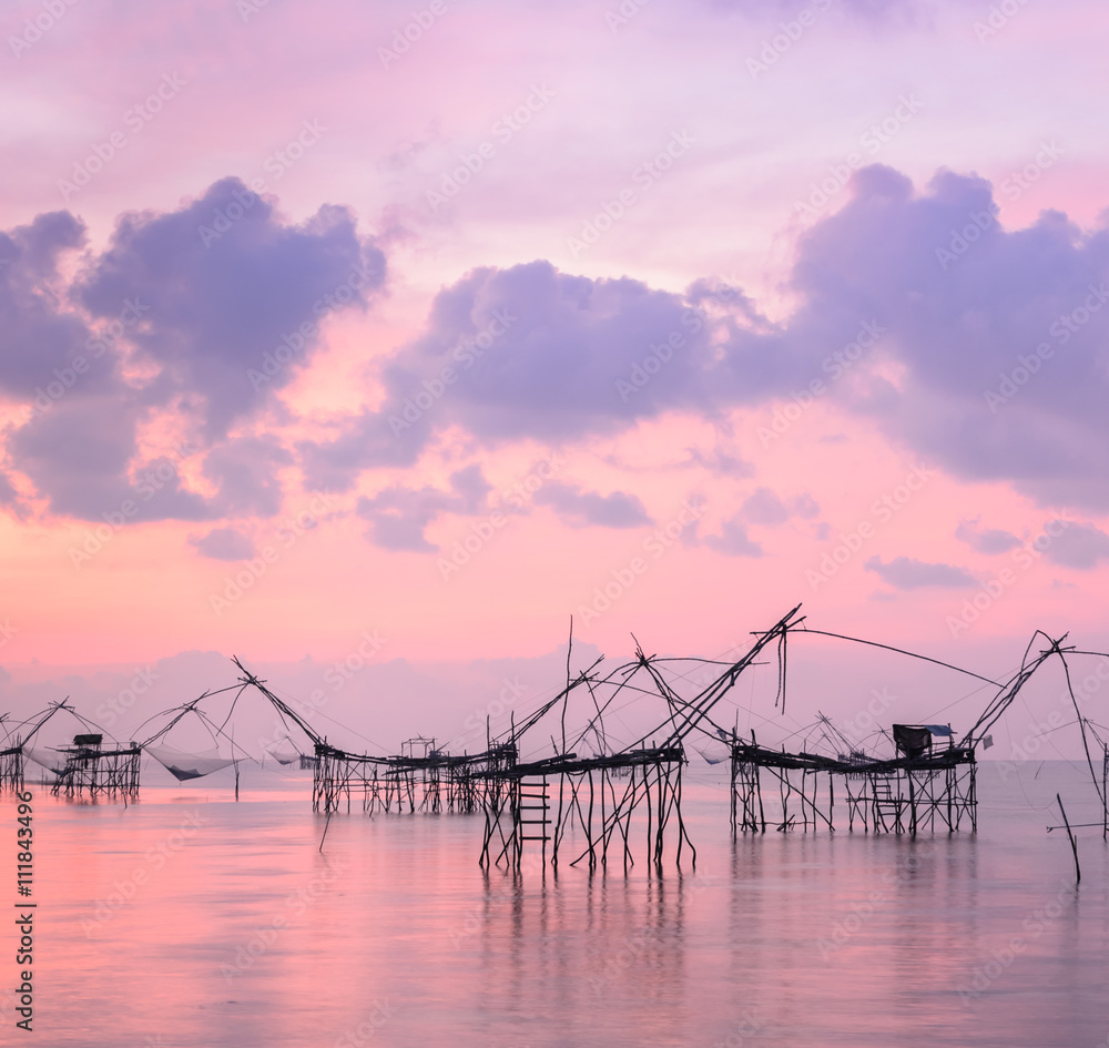 Silhouette fishing net trap at sunrise seascape in Phatthalung, Thailand