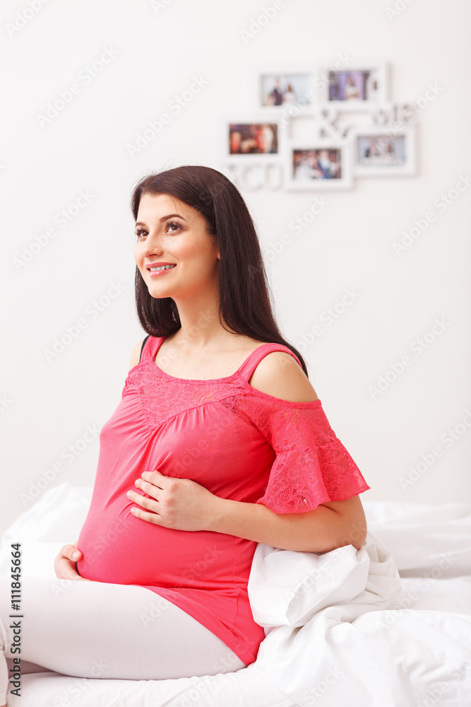 Pretty young future mother is resting in bedroom Pretty young future mother is resting in bedroom