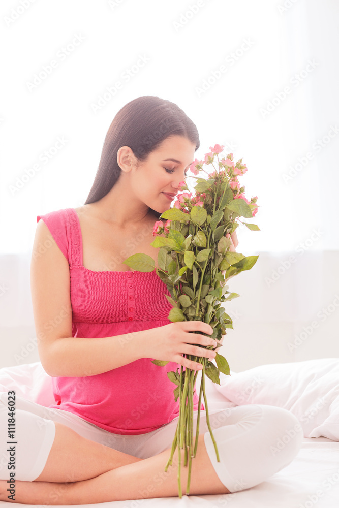 Beautiful expectant mother with cute pink flowers Beautiful expectant mother with cute pink flowers