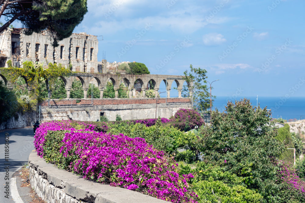 Obraz premium Flowers and ancient architecture in Taormina at Sicily, Italy