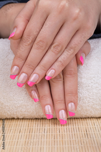 Manicure - Beauty treatment photo of nice manicured woman fingernails. Very nice pink French manicure with silver detail.