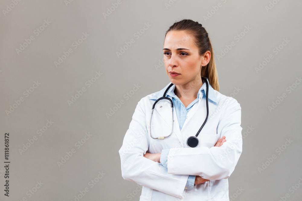 Angry female doctor looking away and thinking about something. Angry female doctor looking away and thinking about something.