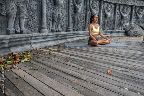 Obraz na płótnie Asian young woman doing hatha yoga in abandoned temple. w salonie