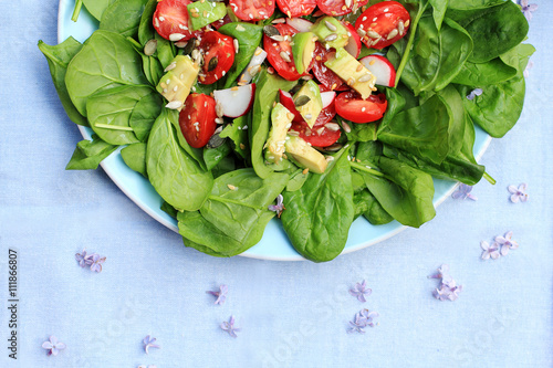 Fresh vegan, vegetarian salad made of spinach, tomatoes and avocado photo