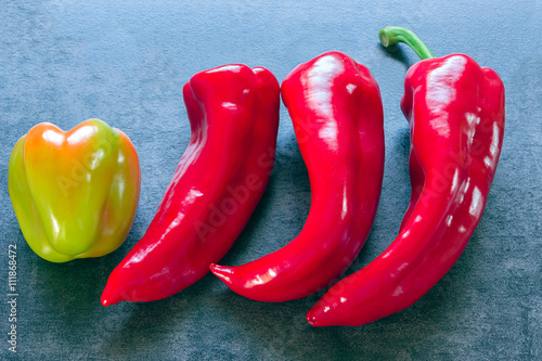 Peppers - three identical and one different in color and shape photo