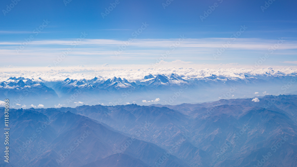 Aerial view of the Peruvian Andes, shot from aeroplane. High altitude mountain range and glaciers. Expansive view.