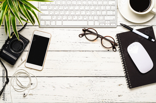 Workspace desk with keyboard, smart phone, camera, earphone, eye