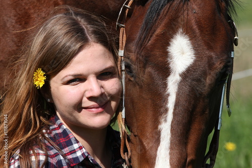 Mädchen mit Blume im Haar und ihrem Pferd